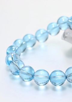 左腕につけた、青いブレスレットで